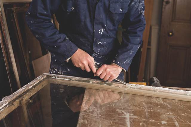 A joiner working on a timber sash window at the bench